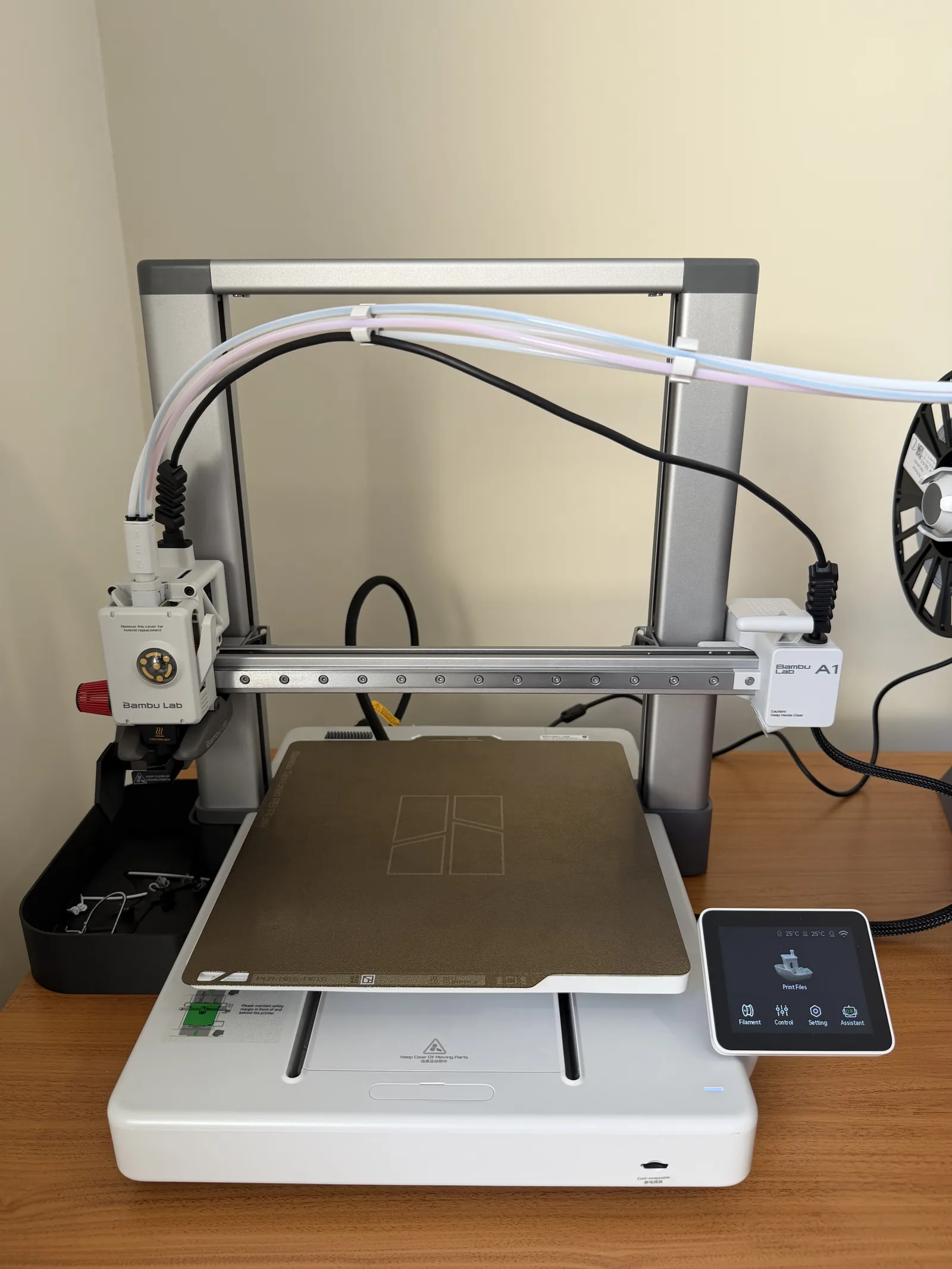 Mesa de impressão texturizada PEI da Bambu Lab A1 com tela de controle touchscreen ao lado no laboratório da Abrahao Labs