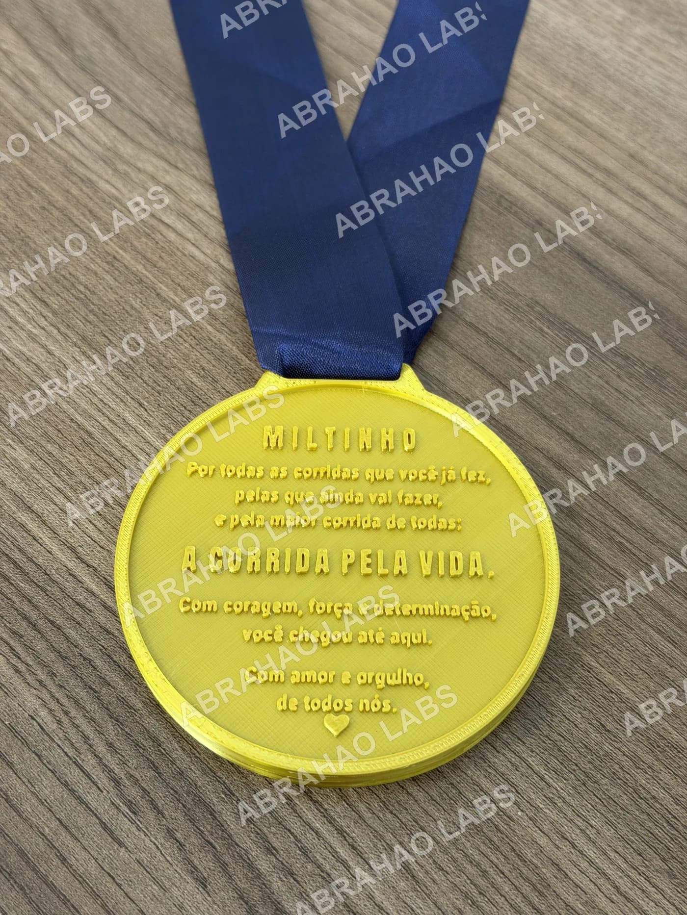 Verso da medalha de homenagem com mensagem da família gravada em relevo: por todas as corridas que você já fez, a corrida pela vida