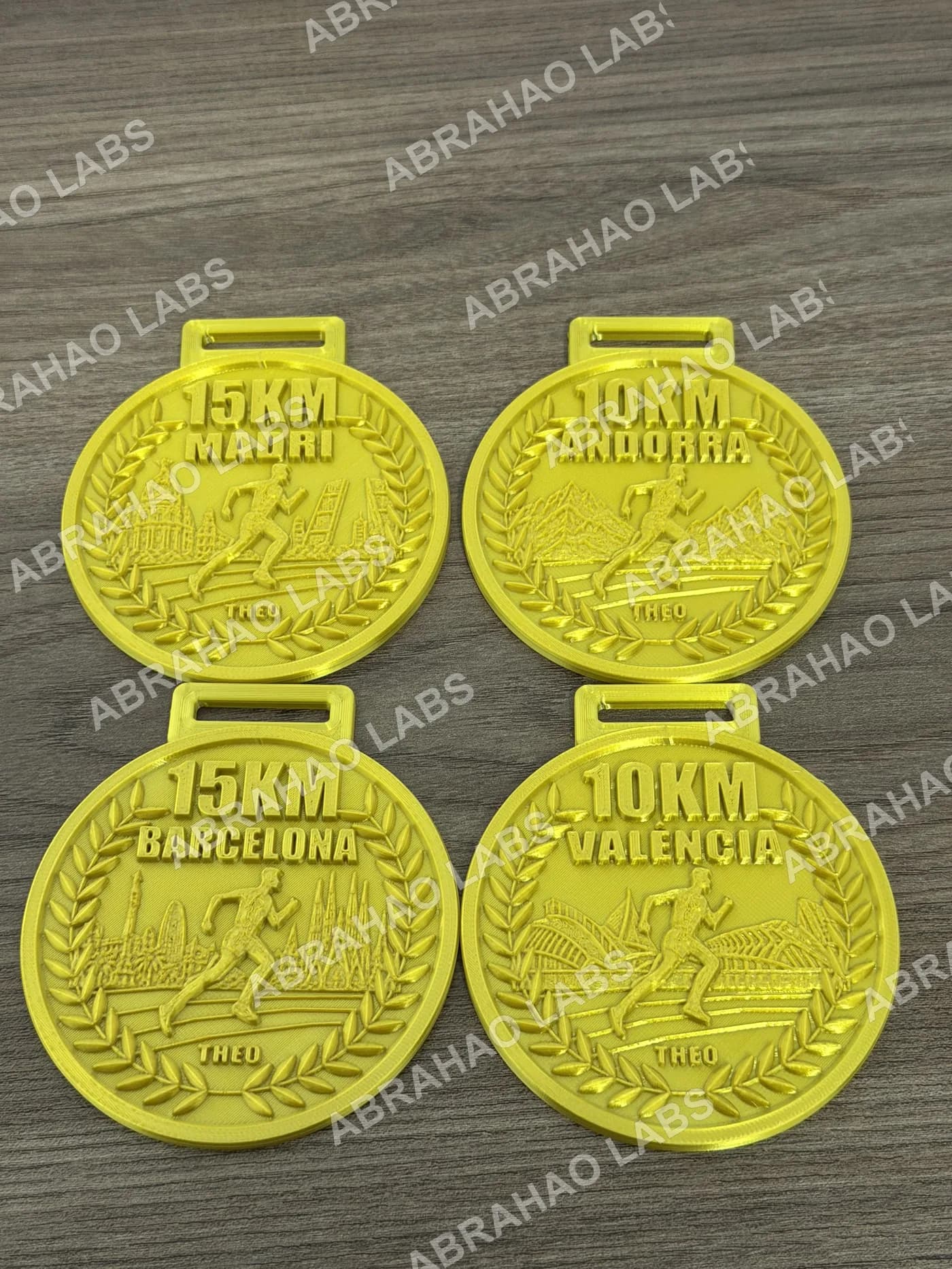 Kit de 4 medalhas de corrida impressas em 3D douradas: 10km Andorra, 10km Valencia, 15km Madri e 15km Barcelona, com skyline de cada cidade em relevo